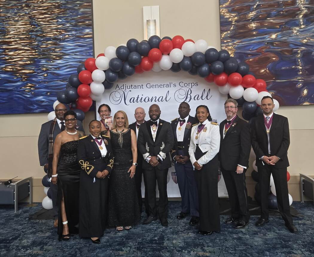 Group photo in front of the Adjutant General's Corps National Ball backdrop