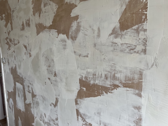 Photo of my first plastered wall with patchy passes, rough joins, and an uneven surface